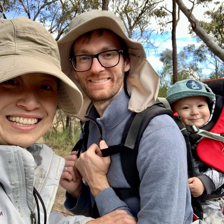 Nicholas and Jingting with child in backpack outdoors